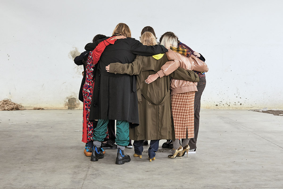 FROM LEFT, RED DRESS AND SHOES MARNI, SOCKS GALLO, TRENCHCOAT BURBERRY, TROUSERS MONCLER 1952, SHOES PRADA, TRENCHCOAT BURBERRY, YELLOW HOODIE K-WAY, TROUSERS LEVI’S, SHOES SANTONI; JACKET, SKIRT AND SHOES MIU MIU, SOCKS VINTAGE;SHIRT PALM ANGELS,VEST VERSACE, TROUSERS MARNI, SHOESVANS