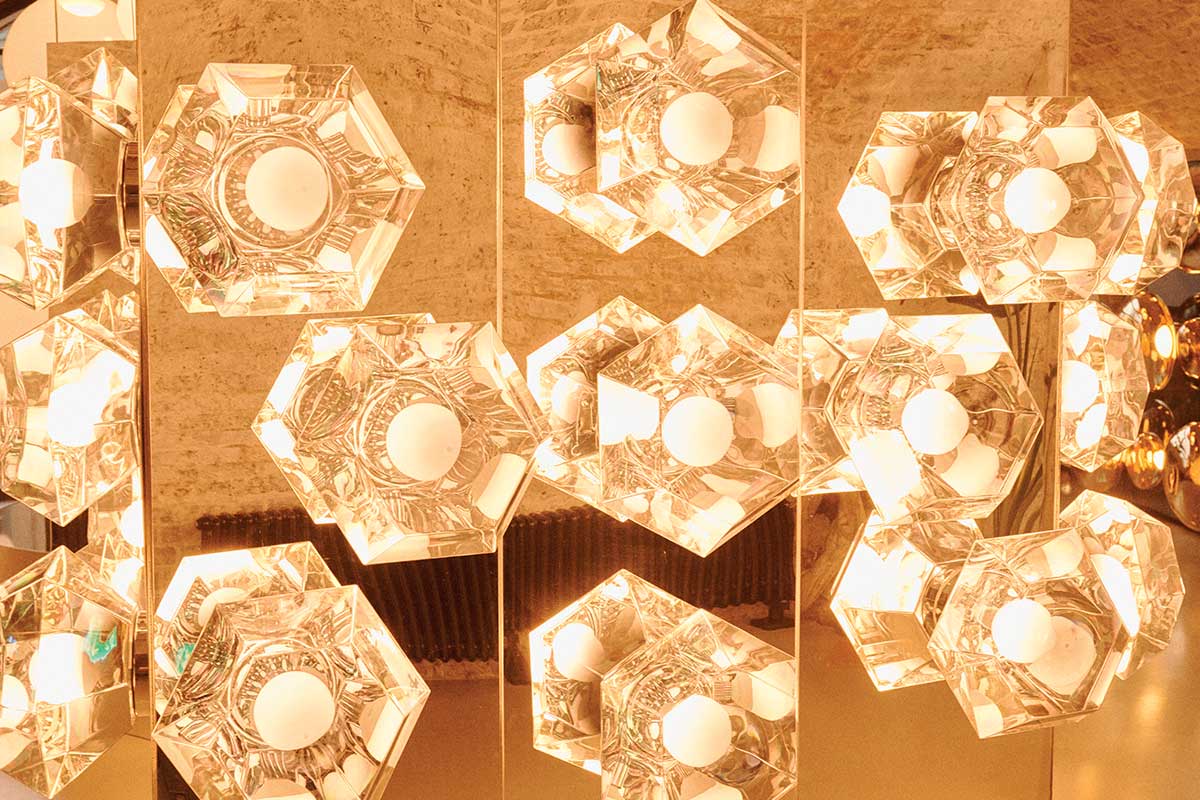 Reflections of the luminous orb repeat within the diamond-cut and vacuum metalized interior of cut surface light