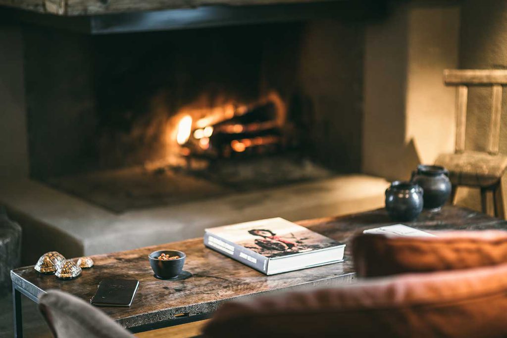 A large open fireplace with sofa seating