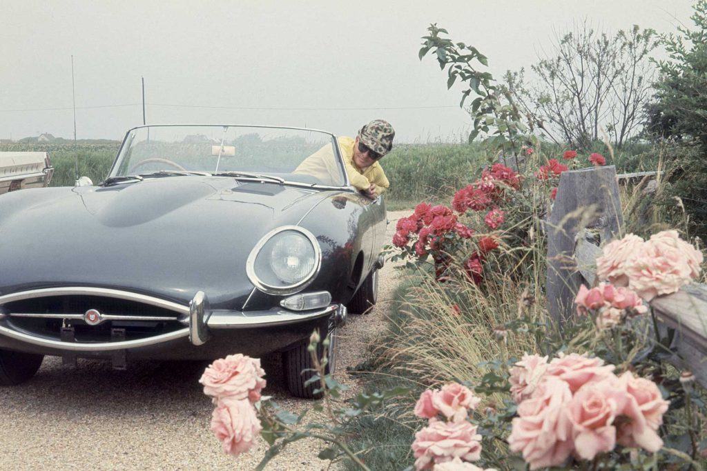 Truman Capote sporto dalla sua Jaguar nel viale della sua casa a Long Island, Vogue, 1965, fotografia di Horst P. Horst