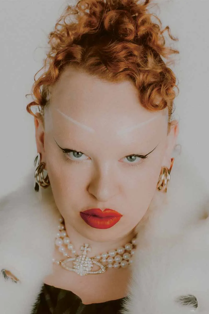 Coat Bottega Veneta, dress Vivienne Westwood x Wolford, necklace Vivienne Westwood, earrings in 18k gold Elsa Peretti® for Tiffany & Co.