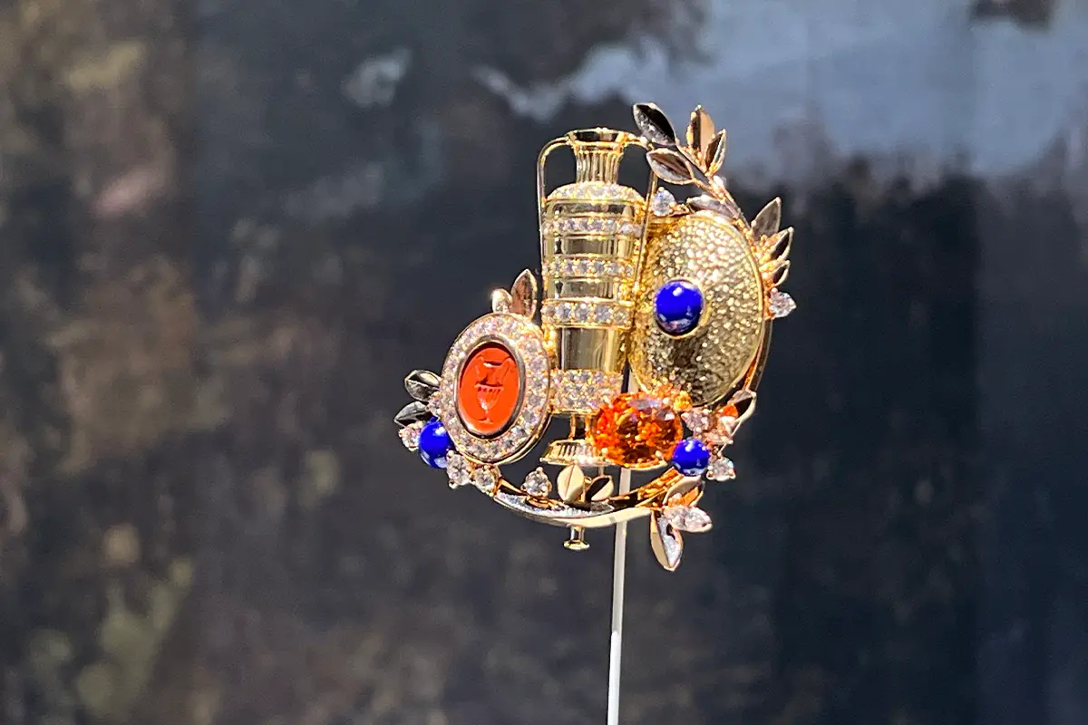 Fermaglio Anfora Van. Cleef & Arpels. Oro giallo, oro rosa, un motivo in diaspro rosso intagliato di 3,47 carati, un granato spessartite taglio ovale di 4,87 carati, lapislazzuli, diamanti