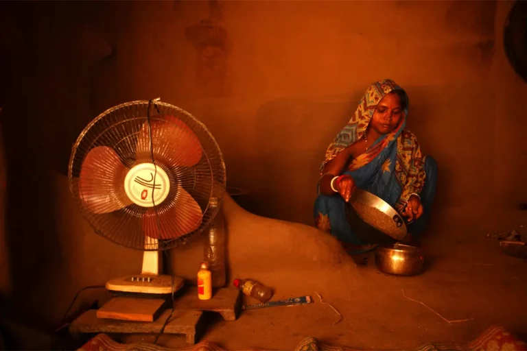 Lampoon, A pregnant woman sits in her mud hut and prepares dinner