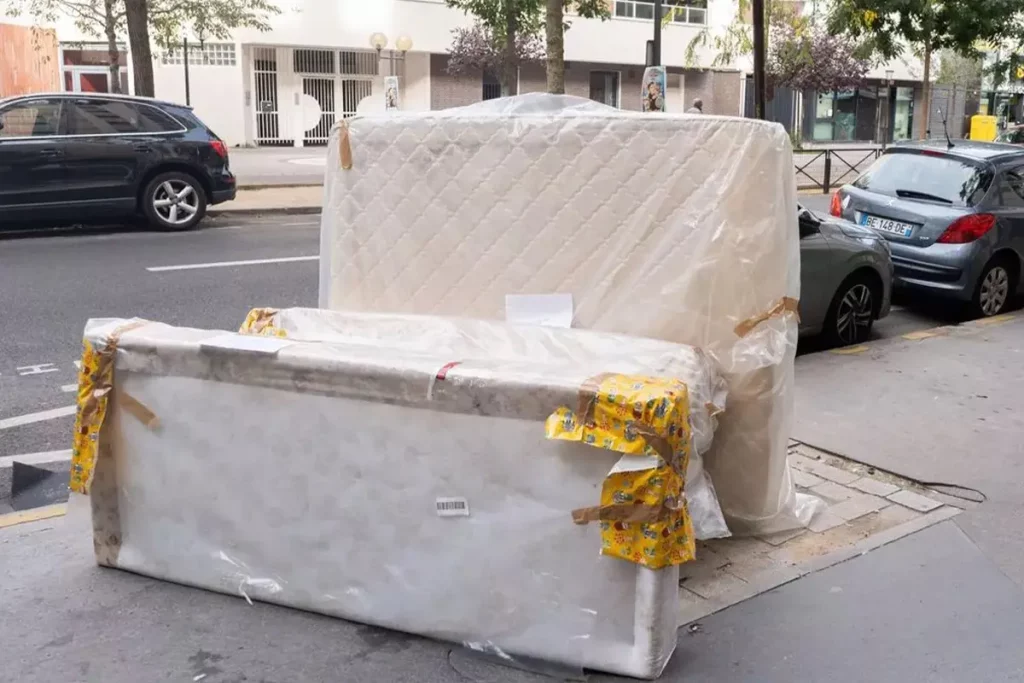 Lampoon, A contaminated mattress and bed frame in a street in Paris awaiting rubbish collection