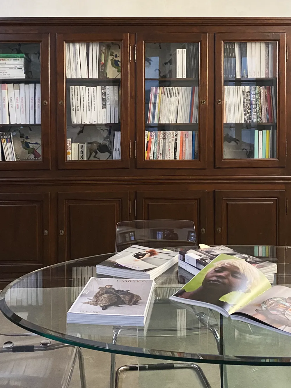 Lampoon Magazine Office Milan, Culture Magzine, wooden cabinet full of magazines, fashion magazines on glass table, design table