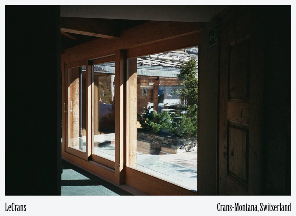 LeCrans, Crans-Montana — panoramic window corridor flooding interiors with daylight to reduce artificial lighting loads
