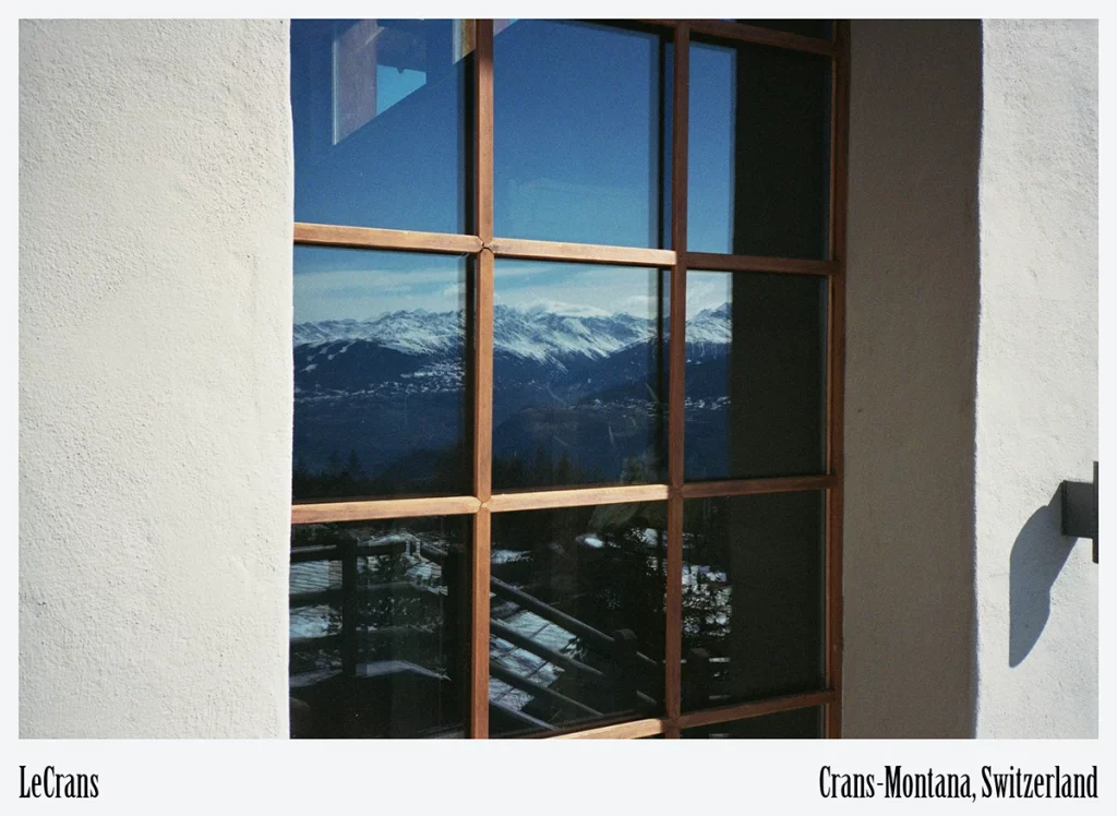LeCrans, Crans-Montana — window mullions framing snowy peaks, merging indoor serenity with outdoor spectacle