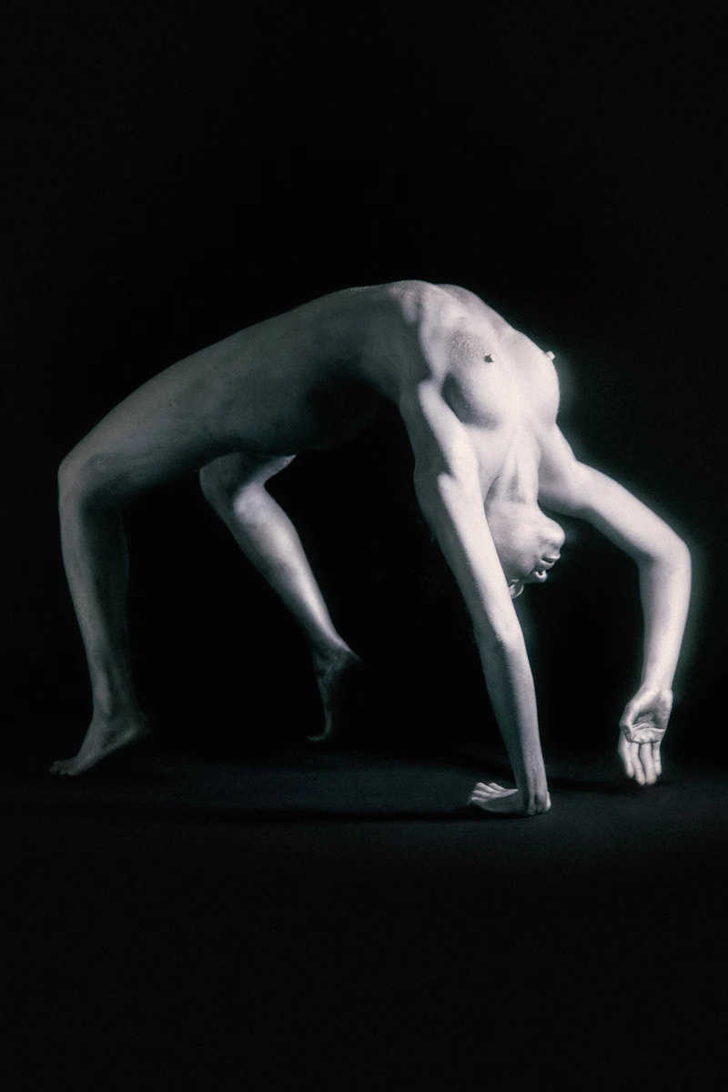 naked woman dancing performing art black background