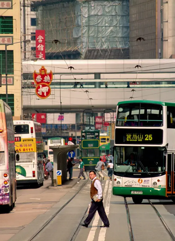 A man crossing tram lines on Hong Kong Island