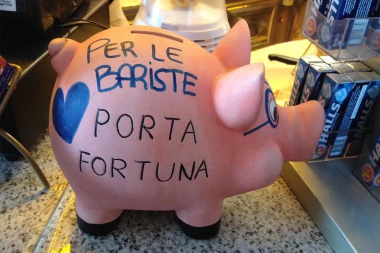A piggy bank on the counter of a bar saying “For the baristas. Lucky charm.” Courtesy of the author