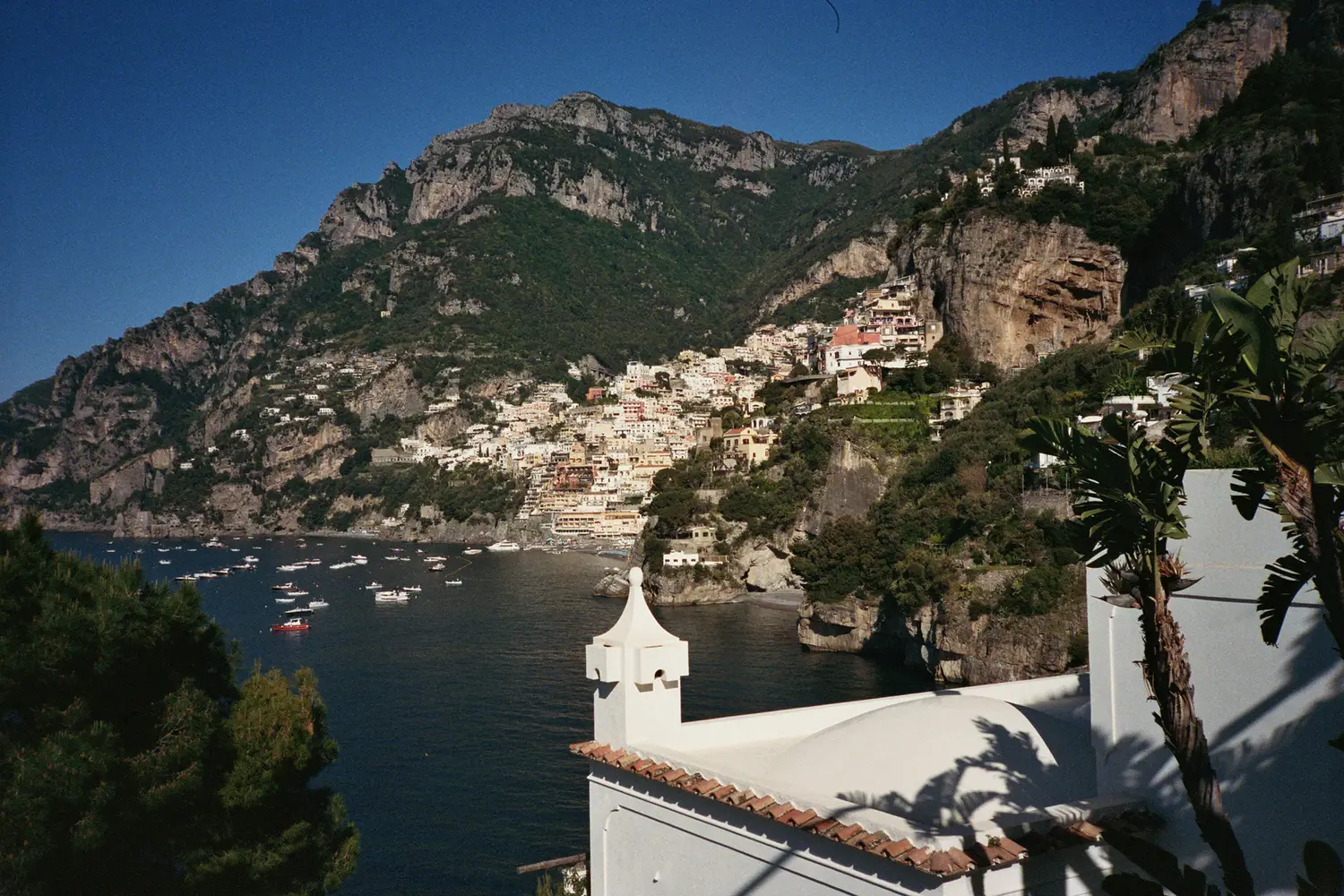 Balcony framed by date palms opens onto the cove—one of many intimate visual corridors threaded through the property_2