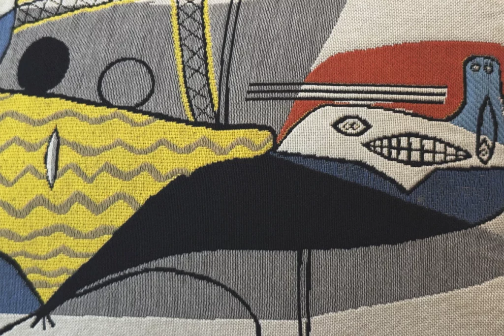 Brach Paris, lobby – A Jules Pansu tapestry cushion translates Picasso’s Cubism into textured colour, signalling the hotel’s art-infused DNA