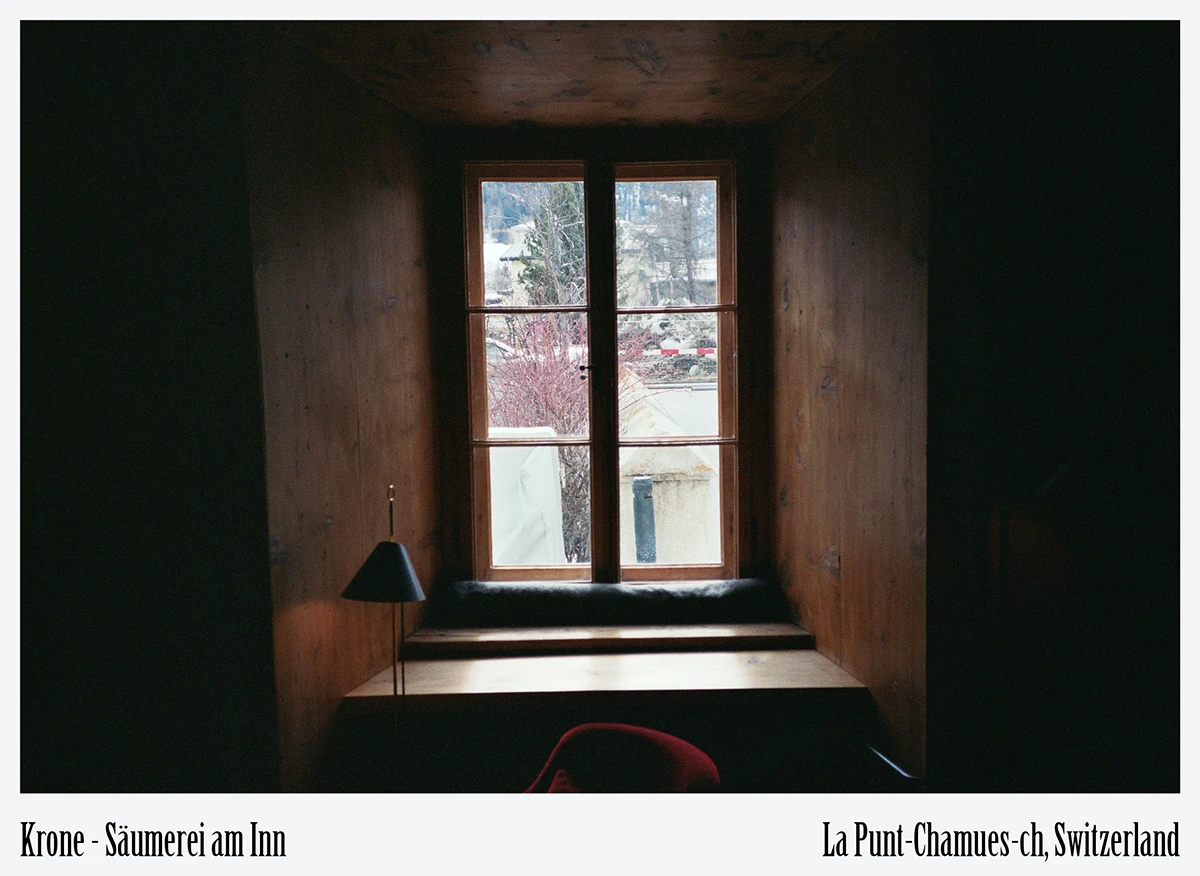 Deep-set window framing Alpine village view in sustainable stay at Krone La Punt