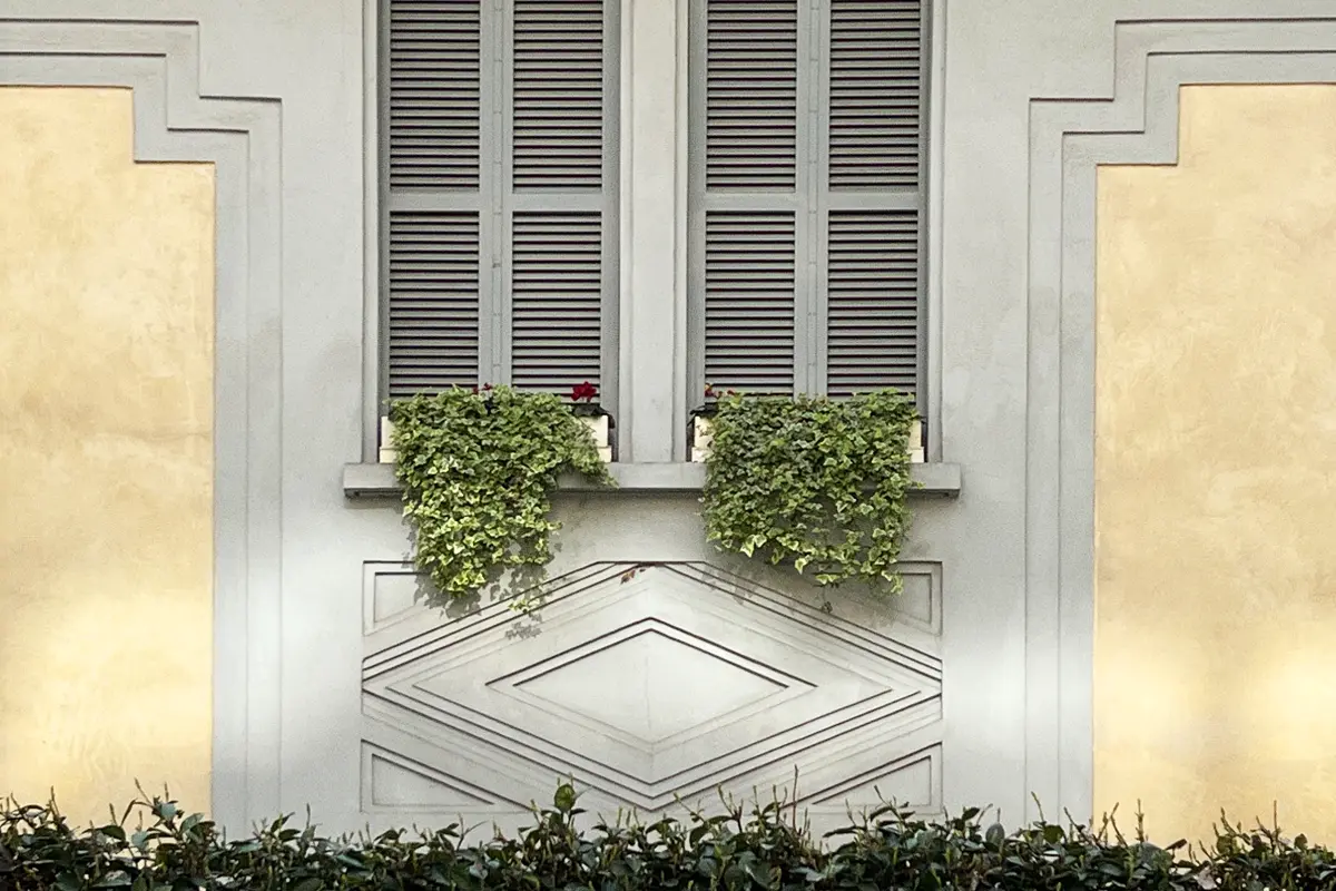 Grey window with green plants in via Carlo Ravizza, Milan