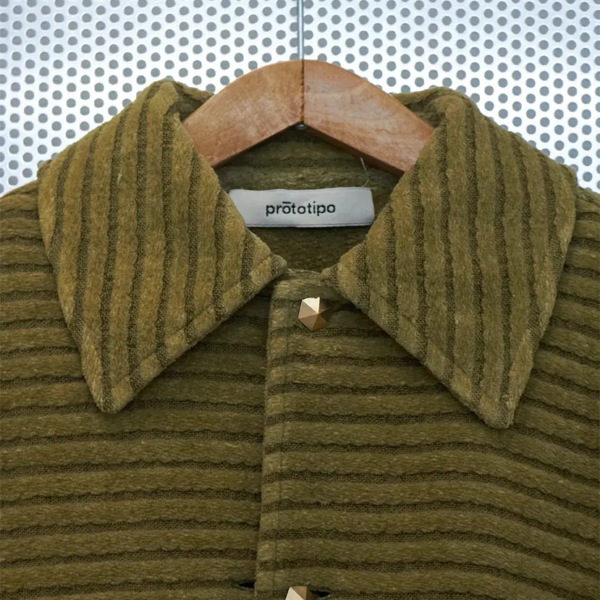 Collar detail of the velvet hemp bomber jacket. Hemp and cotton fabric in a mud green color, with chenille knitted details.