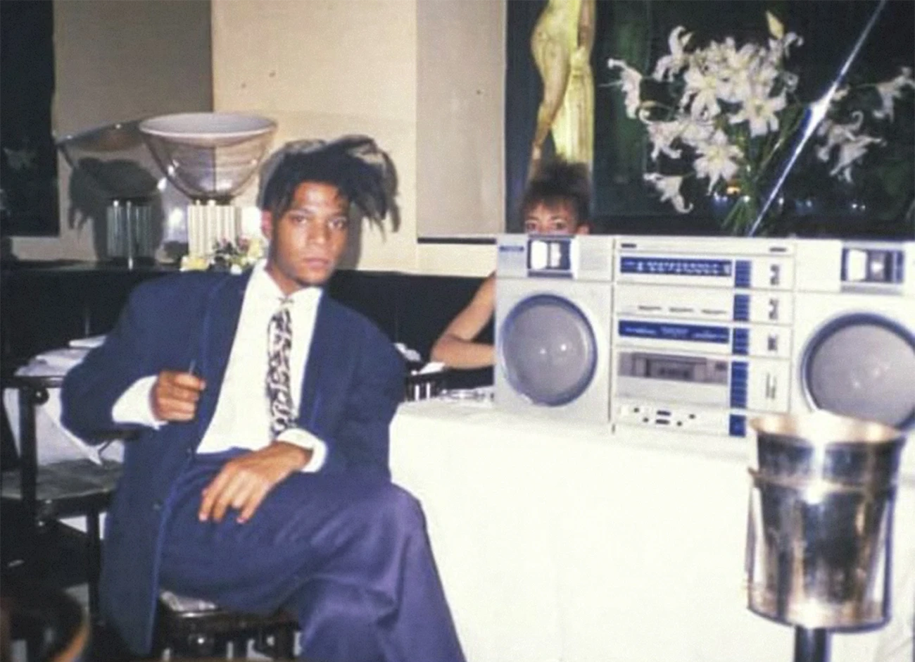 Jean-Michel Basquiat sitting with a Fisher PH-480k boombox at Mr. Chow in New York City, 1986. Photo by Tseng Kwong Ch