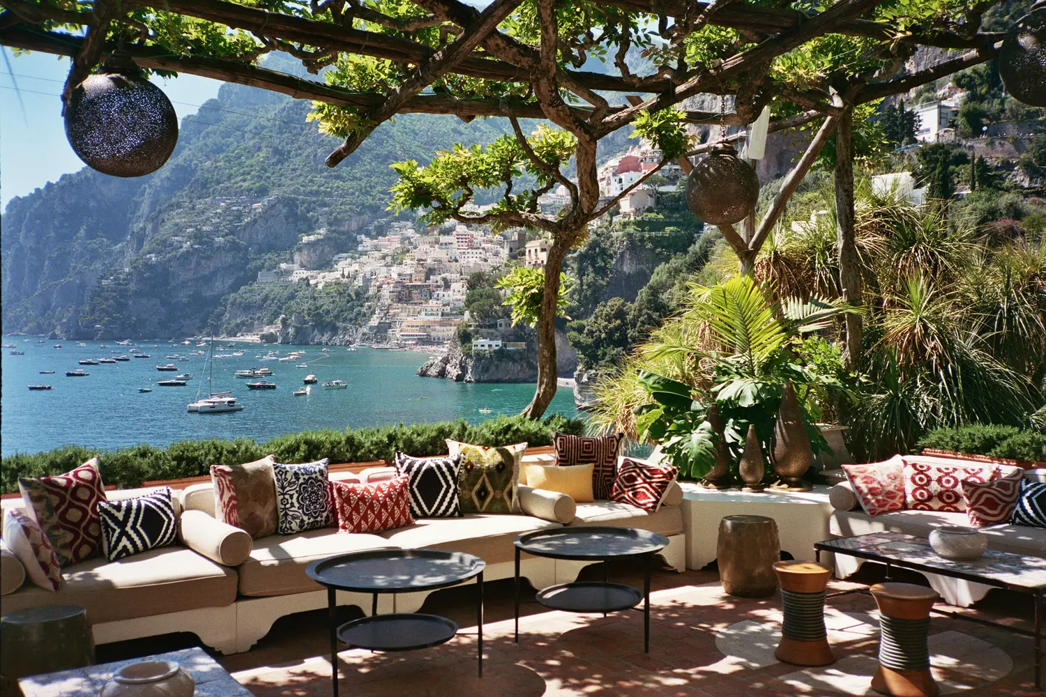 Open-air salon on a cliff-edge terrace/ wrought-iron sofas, hand-woven linen cushions, and the Tyrrhenian Sea—Villa Treville