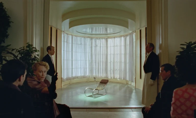 László’s chair in the Van Buren library with strapping inspired by American lawn chairs. Courtesy of Universal Pictures|The team of The Brutalist inside the Van Buren library. Courtesy of Universal Pictures|Adrien Brody as László Tóth