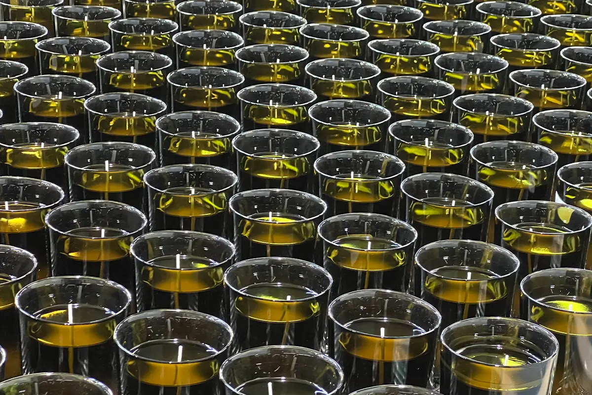 The wick is threaded into the center of the candle mold, which is usually made of glass