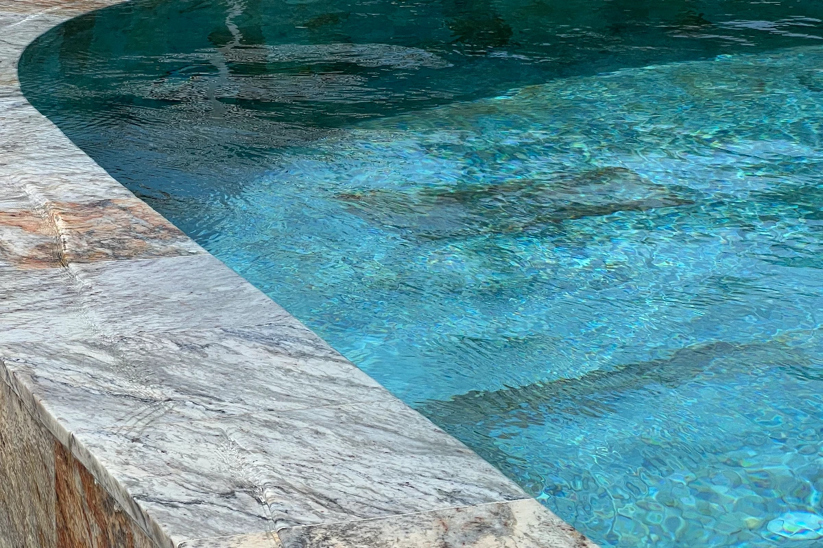 Close-up of marble pool edge and turquoise waterClose-up of marble pool edge and turquoise water