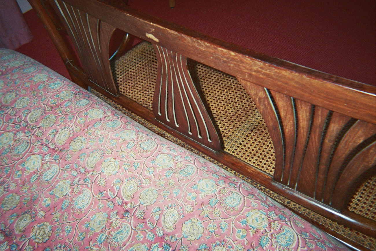 Pink and red linen bed with wooden chair lounge