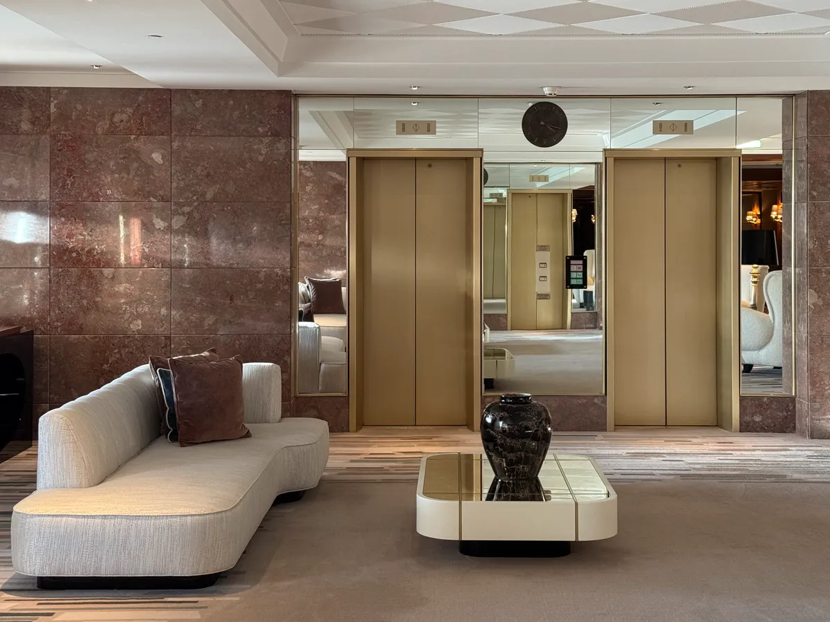 Upper-floor hall lounge at Four Seasons Ritz Lisbon: mid-century Portuguese modernism softened by patterned carpets, custom upholstery and low sofas built for long conversations — a quiet antechamber between guest rooms and the hotel’s art-lined public spaces
