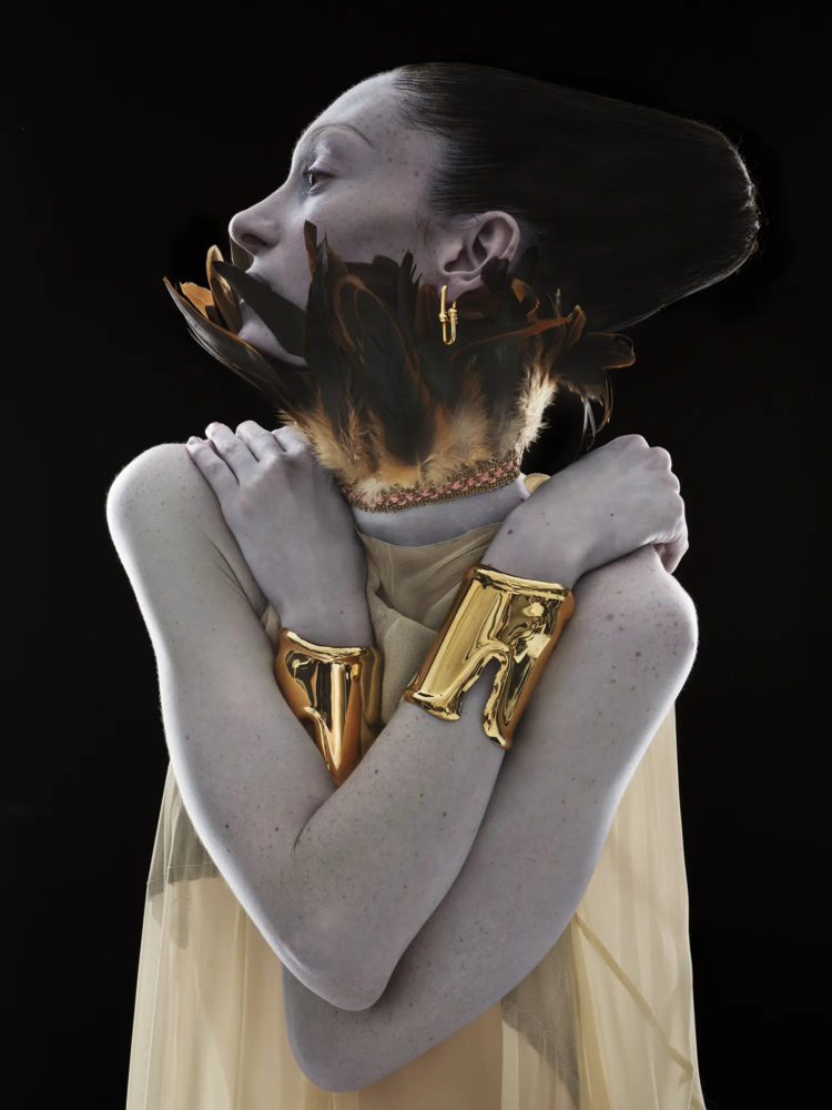 Elsa Peretti® large bone cuffs in yellow gold and hardwear large link earring in yellow gold Tiffany & Co, dress Stylianos Kamperis, feathers Rellik, photography Nick Knight