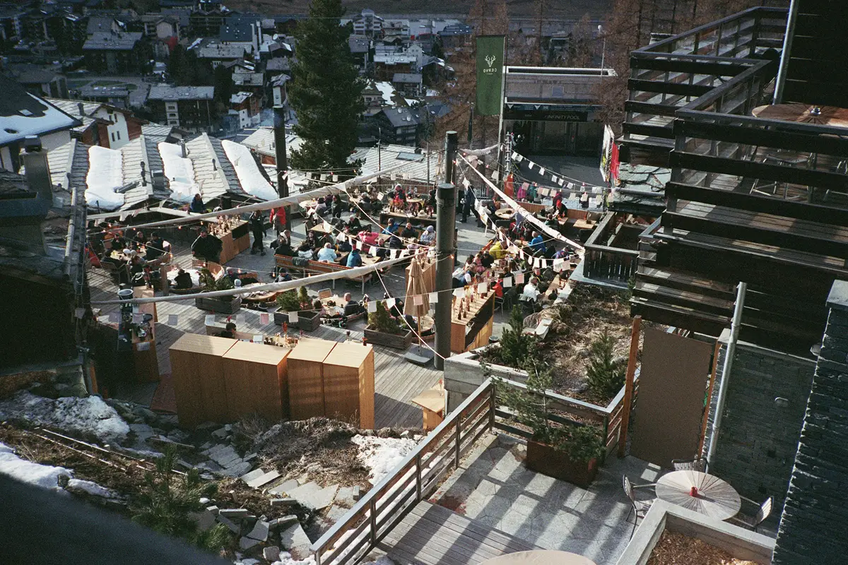 Zermatt. Sun-filled terrace buzzing with après-ski crowds. Cervo Mountain Resort