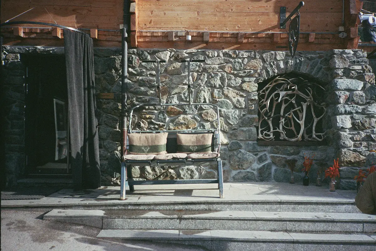 Zermatt. Stone patio with Cervo emblem and log bench. Cervo Mountain Resort