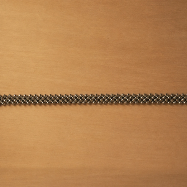 Handcrafted titanium necklace by Lampoon, composed of 164 shield-shaped elements and presented in a custom-designed wooden collector's box with hemp lining