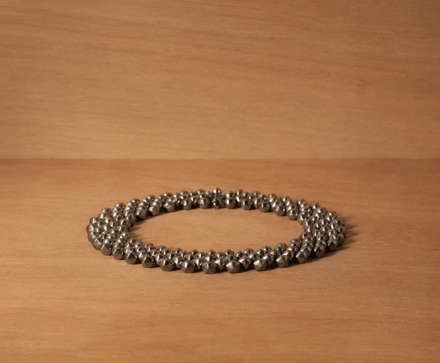 Handcrafted titanium necklace by Lampoon, composed of 164 shield-shaped elements and presented in a custom-designed wooden collector's box with hemp lining
