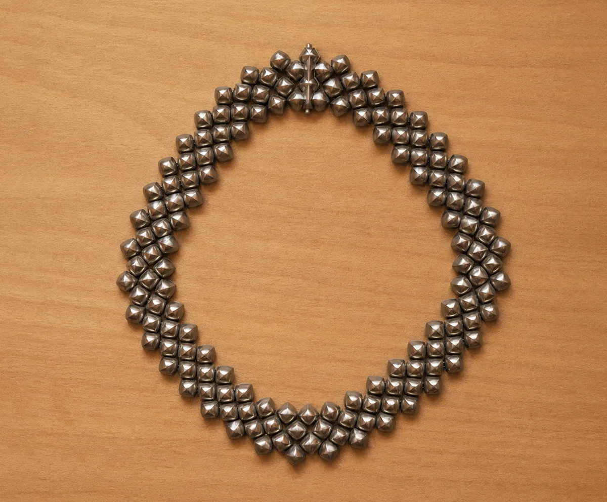 Handcrafted titanium necklace by Lampoon, composed of 164 shield-shaped elements and presented in a custom-designed wooden collector's box with hemp lining