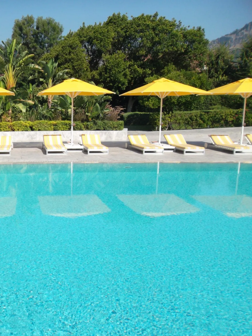 The swimming pool at D-Resort Göcek, framed by yellow parasols