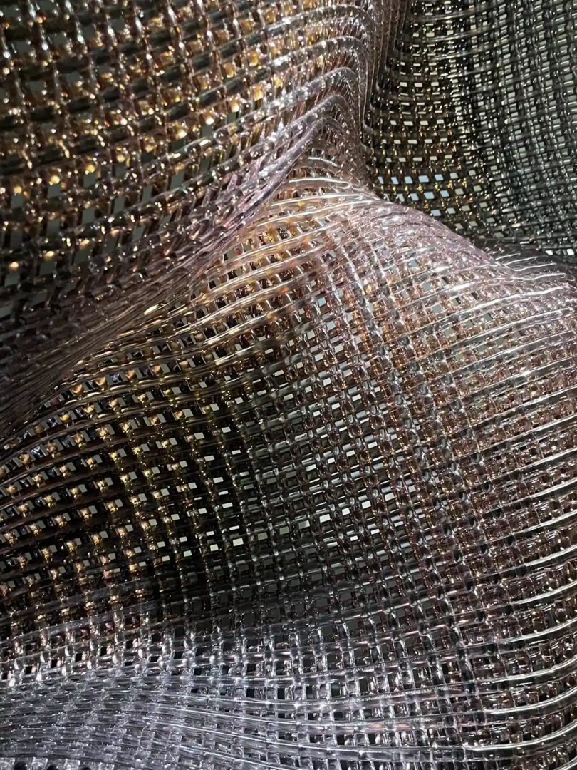 Detail of Cathryn Shilling’s woven glass sculpture at Homo Faber 2026 in Venice, showing transparent glass rods shaped like flowing fabric.