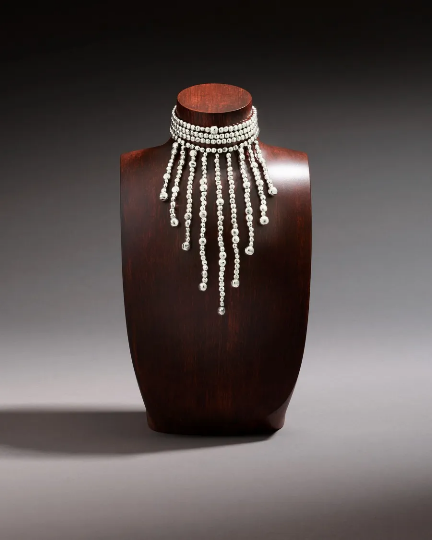 DoDo silver-tone beaded choker with multiple cascading strands of polished beads, displayed on a dark wooden jewelry bust.