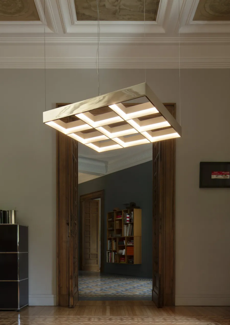 Flos Frame 3x3 pendant lamp designed by Michael Anastassiades, featuring an illuminated geometric grid suspended in an elegant interior with wooden doorways and decorative ceilings