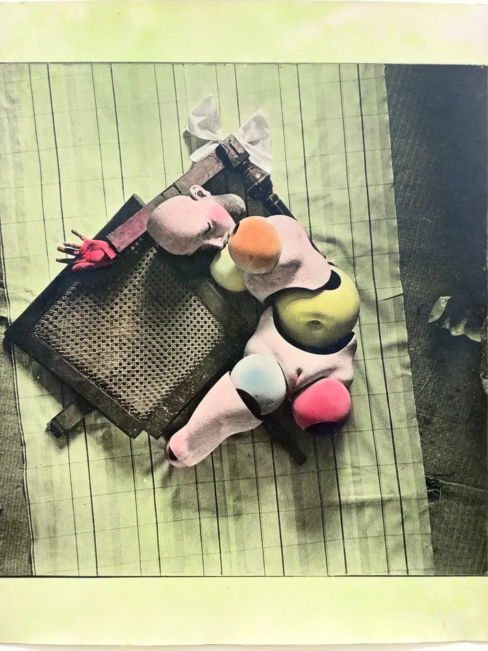 Surrealist composition by Hans Bellmer featuring fragmented doll-like body parts, rounded colored forms and a wooden chair arranged on a pale patterned surface.