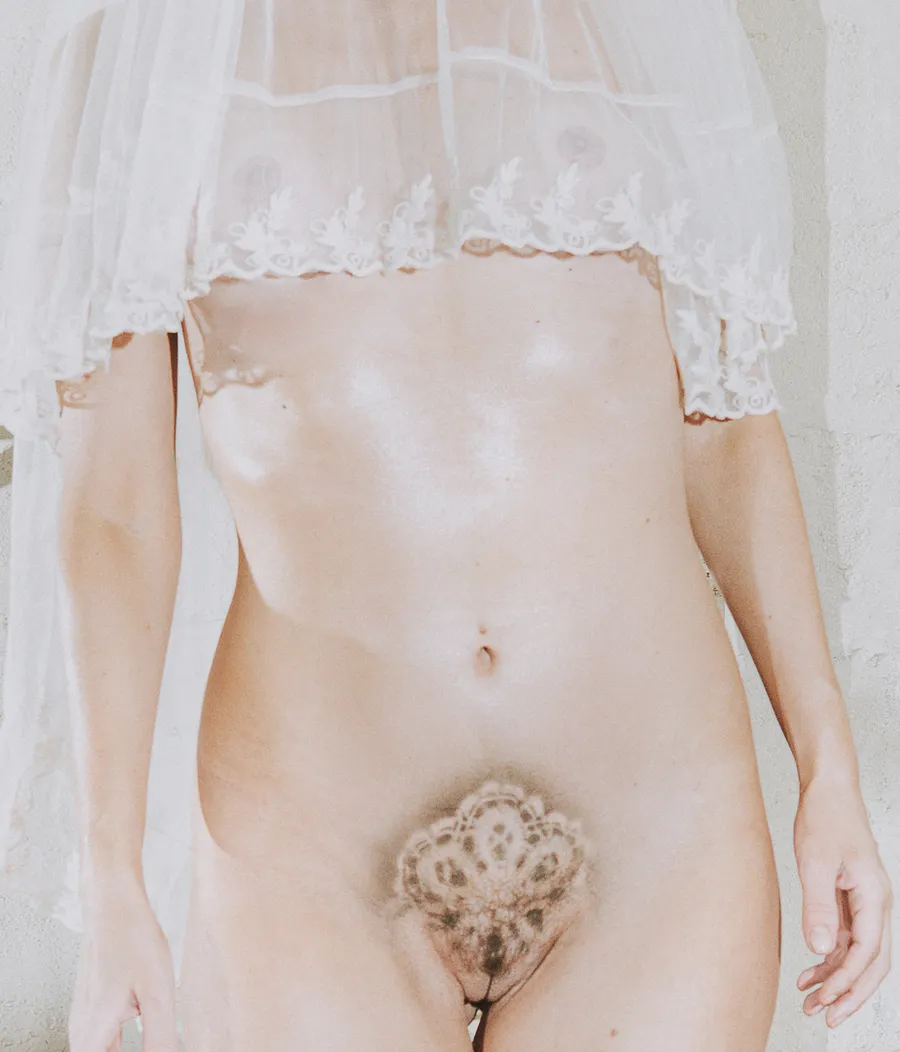Artistic nude portrait of Maja Malou Lyse wearing a sheer white lace veil, with pubic hair styled in an intricate floral pattern, photographed by Lalo + Eva