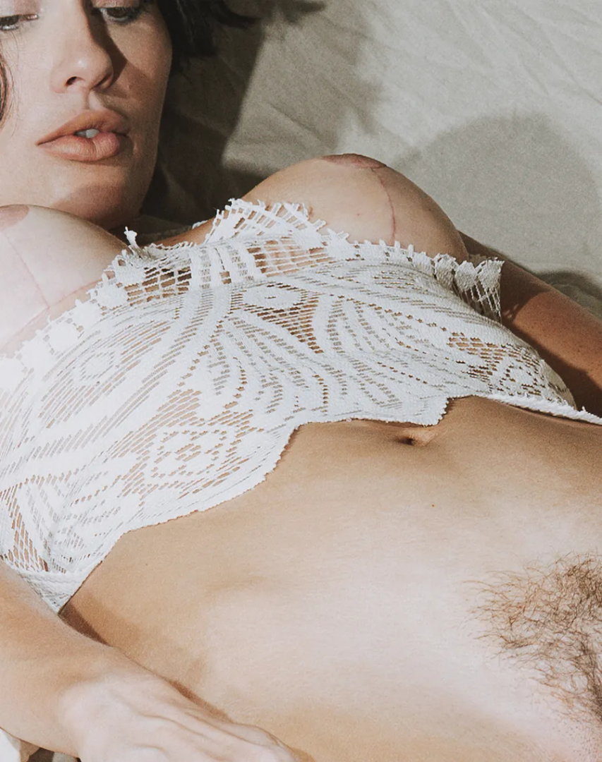 Intimate close-up of Maja Malou Lyse reclining in a delicate white lace top, revealing natural skin and body hair, photographed by Lalo + Eva