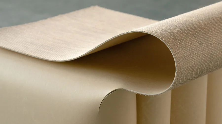 Close-up of a folded linoleum sheet showing its textured backing, smooth surface and curved edge.