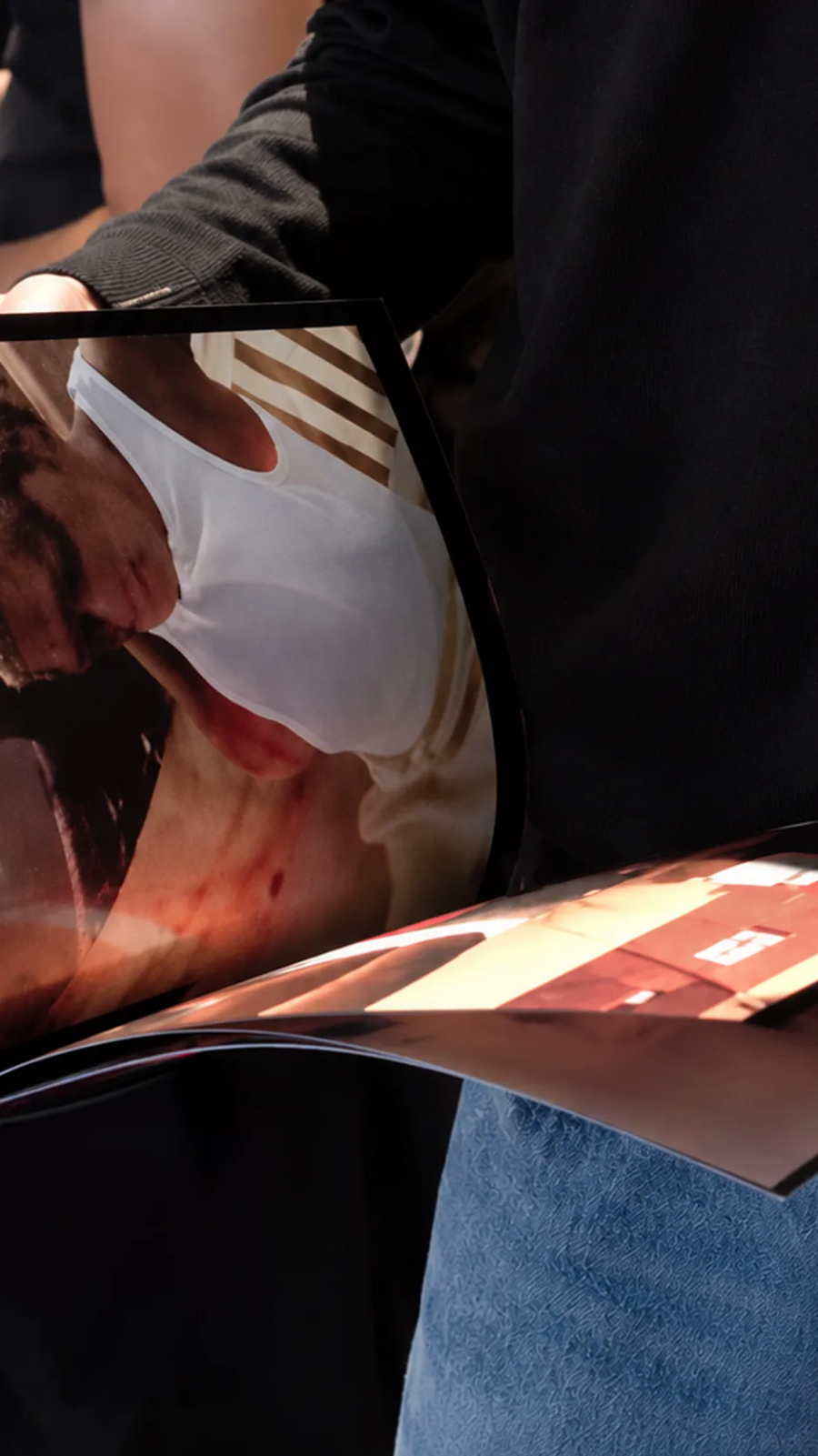 Visitor leafing through a glossy photography magazine at Mag to Mag 2026, showing a close-up portrait printed across a curved page.