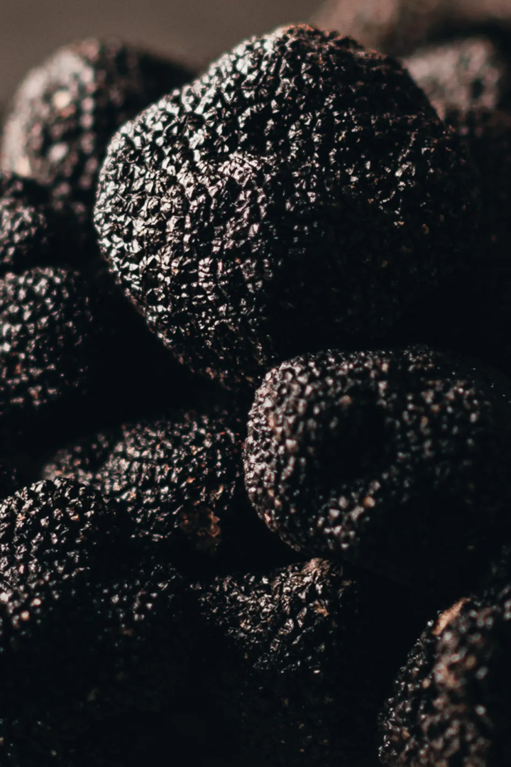 Close-up of black truffles showing their rough, irregular surfaces and dark textured skin.