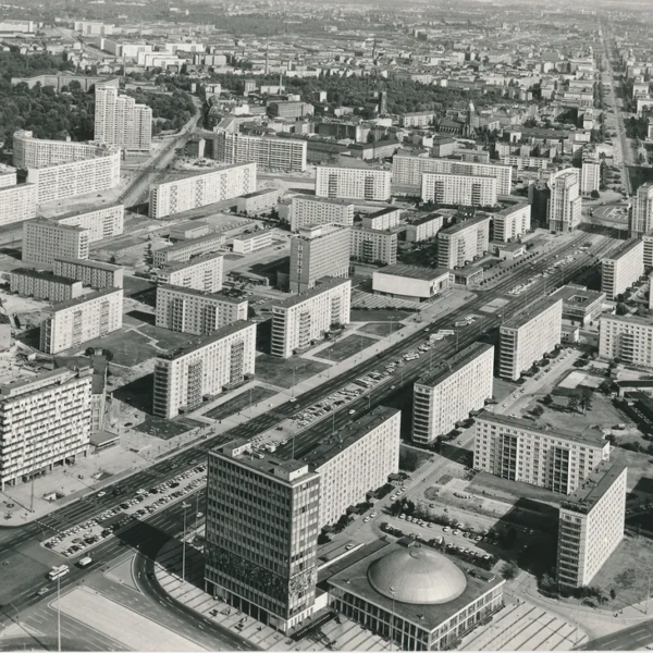 Aerial black-and-white photograph of Karl-Marx-Allee in East Berlin in 1970, showing prefabricated apartment blocks, wide boulevards, intersections and Kino International.