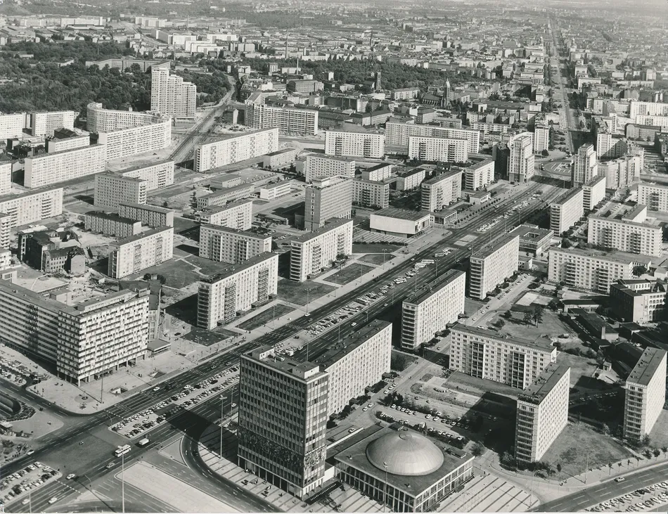 Aerial black-and-white photograph of Karl-Marx-Allee in East Berlin in 1970, showing prefabricated apartment blocks, wide boulevards, intersections and Kino International.