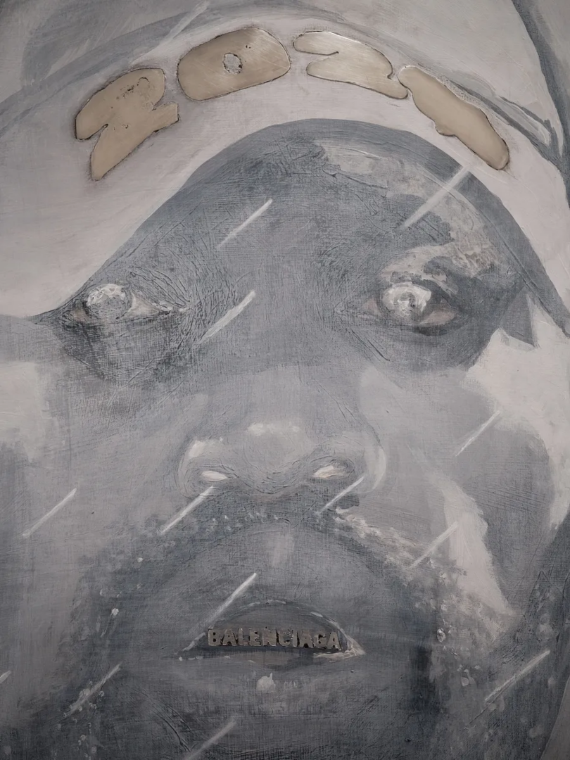 Grey painted portrait of a face with POST across the forehead and BALENCIAGA across the mouth, showing scratched and textured surfaces.