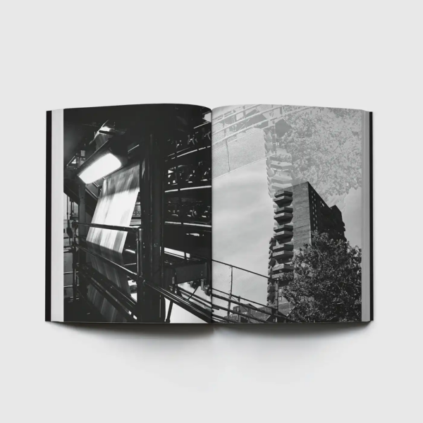 Open book displaying two black-and-white photographs: a printing press with paper moving through industrial machinery on the left, and a high-rise building with projecting balconies framed by trees on the right.