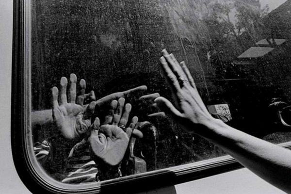 Gilles Peress, Hands touching through bus window, Bosnia , ca. 1993